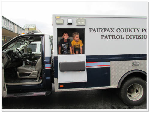 Children enthusiastically explored a police vehicle at the Annandale Shopping Center. 